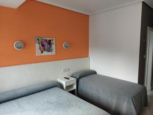 Mahora塞万提斯酒店的一间设有两张床和橙色墙壁的客房