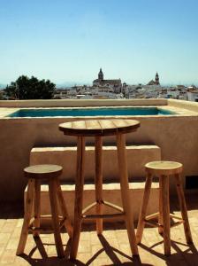 Fuentes de AndalucíaLA POSADA DEL LIMONERO的阳台上设有一张木桌和两张凳子