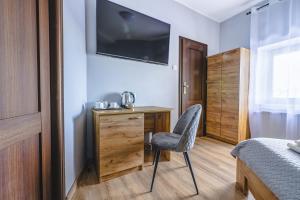 格但斯克Royal Gdansk的一间卧室配有椅子和一张书桌及电视