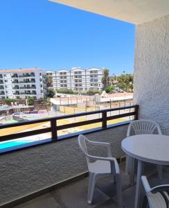 马斯帕洛马斯The SunSpot Apartment Playa del Inglés的设有一个配有桌椅并享有美景的阳台。