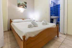 帕拉利亚卡泰里尼斯Lucia Hotel Paralia的卧室配有带白色床单和水槽的床