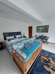 新弗里堡Lumiar Eco Lodge - Chalé Telhado Verde的一间卧室配有一张大床和一张沙发