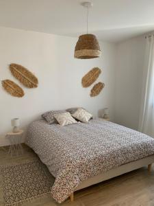 RanvilleLa maison de la vallée的一间卧室配有一张床,墙上还装了一些篮子