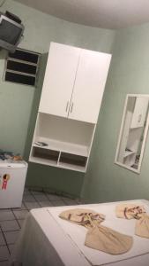 卡鲁阿鲁Pousada Ipojuca的客房设有两张床和白色橱柜。