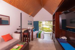 希克杜沃Serendipity Lake - Hikkaduwa的客房设有床、沙发和电视。
