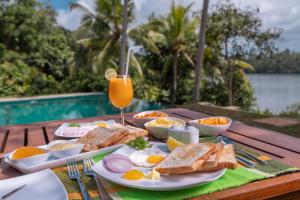 希克杜沃Serendipity Lake - Hikkaduwa的包括鸡蛋、烤面包和一杯橙汁的早餐桌