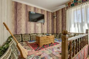 卡拉科尔Ordo Hotel的客厅配有沙发和墙上的电视
