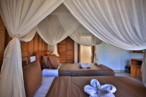 珀尼达岛宾塔格度假酒店的卧室设有两张床,配有白色窗帘
