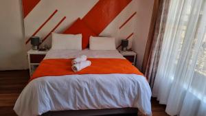 PhuthaditjhabaEpic Den Lodge的一间卧室配有一张床,上面有两条毛巾