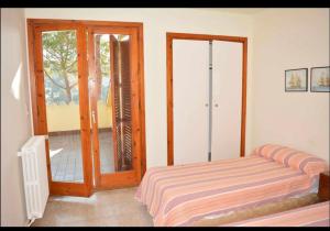 滨海托萨Villa in Tossa de Mar (Santa María de Llorell)的一间卧室设有一张床和一个滑动玻璃门