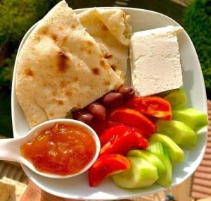 开罗Kenzy guest house的一块带蔬菜和奶酪的食品和勺子