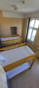 马赛Auberge de Jeunesse HI Marseille Bois-Luzy的一间设有三张床的房间,设有窗户