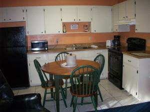 埃奇沃特LLC全套房汽车旅馆的一间带桌椅的厨房和一间带白色橱柜的厨房