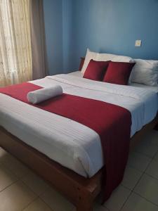 内罗毕MAMU'S RESIDENCE near JKIA的一间卧室配有一张带红色枕头的大床