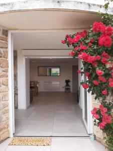 皮埃尔弗-迪瓦尔Appartement climatisé au calme en Provence的墙上有红色玫瑰的开放式走廊