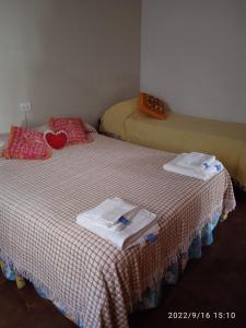 马德普拉塔Villa Lidia的一间设有两张床铺和毛巾的房间