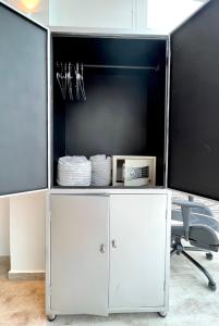 MacanalLa Vista EcoHouse的白色的橱柜,配有电视和椅子