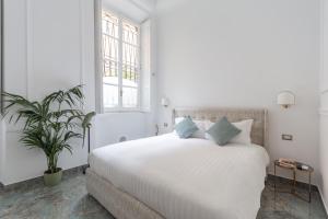 米兰Duomo Smart Suites的白色卧室配有白色床和蓝色枕头