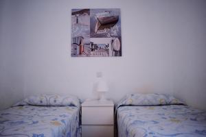 莫甘Bungalow Guayana的卧室配有两张床,墙上挂着一幅画