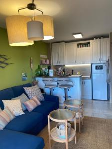 阿尔姆尼卡Apartamento con vistas en Mariote的一间带蓝色沙发的客厅和一间厨房
