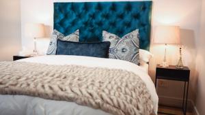 米德兰Luxury Apartment at Ellipse Waterfall, Midrand Near Mall of Africa的一间卧室配有一张大床和蓝色床头板