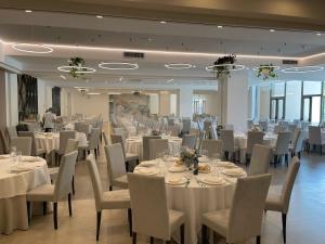 阿夸桑塔泰尔梅Hotel Ristorante Tre Lanterne & SPA的宴会厅配有白色的桌椅