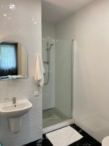 什切齐内克金色小屋膳食公寓餐厅酒店的带淋浴和盥洗盆的白色浴室