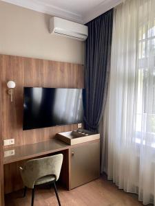 什切齐内克金色小屋膳食公寓餐厅酒店的客房设有电视、椅子和书桌。