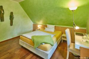 比勒费尔德布兰德布希瓦尔德酒店的一间卧室设有一张带绿色天花板的床。