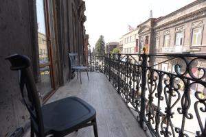 久姆里Aratta Royal Hotel的市景阳台(带椅子)
