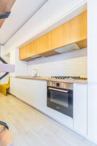 布加勒斯特Amazing Luxury Aviatiei的厨房配有白色橱柜和烤箱。