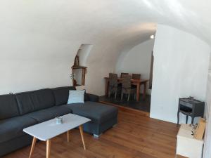 EnneyAppartement vouté en Gruyère dans l'Intyamon的客厅配有沙发和桌子