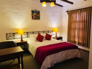 瓦拉斯蒙特雷庭院酒店的一间卧室配有一张床、一张桌子和两盏灯。