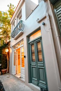 雅典Belle Athenes - Luxury Rooms at Monastiraki Railway Station的一座带绿门的房子的前门