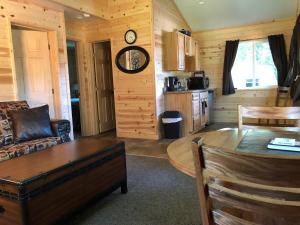 塔尔基特纳Susitna River Lodging, Backwoods Cabins的客厅配有沙发和桌子