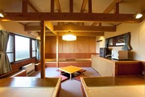 竹田久住高原小屋酒店的客厅配有木制家具和电视