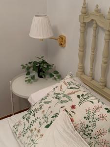 萨拉戈萨Precioso piso recién reformado en Zaragoza的一张带枕头、台灯和桌子的床