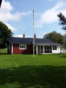 奥萨Orsastuguthyrning-Hansjö的院子里有旗帜的红色房子