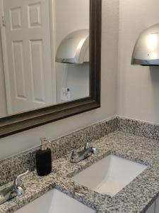 杰克逊维尔Roosevelt Inn的浴室的柜台设有水槽和镜子