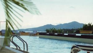 美娜多格兰普里美娜多酒店的一个带椅子的游泳池,背景是山脉