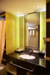 美娜多格兰普里美娜多酒店的一间带水槽和镜子的浴室