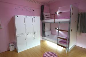 奥南海滩奥南海滩爱迪尔旅舍的粉红色的客房设有双层床和梯子