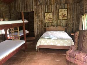 Hacienda Santa MaríaSanta Maria Volcano Lodge的一间带两张双层床和一张沙发的卧室