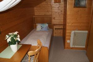 伦韦格Gästehaus Ferienwohnungen LACKNER的小房间设有一张床、一张桌子和一张桌子
