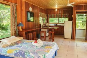 Aimbuei BayAore Hibiscus Retreat的一间卧室配有一张床,厨房配有冰箱
