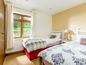 奇平卡姆登平坎普登谷仓乡村别墅的一间卧室设有两张床和窗户。