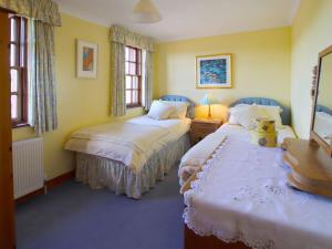 Kingholm QuayConheath Gatelodge Cottage的配有两张床铺的黄色墙壁和窗户