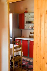 扎布利亚克Apartment Aleksić的厨房配有红色橱柜、桌子和椅子