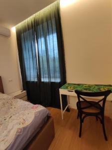 基辅Lux apartment, near metro Vasylkivska的卧室配有1张床、1张桌子和1把椅子