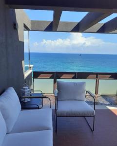 巴里Attico Suite spiaggia Bari的阳台配有两把椅子,享有海景。